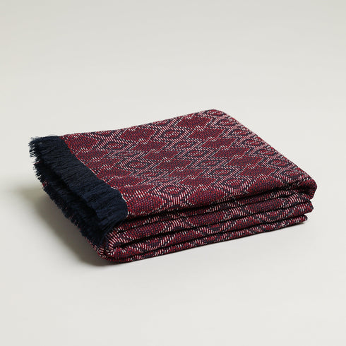 Maroon, navy, and white jacquard geometric throw blanket folded up
