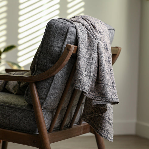 Black and grey boucle jacquard throw blanket styled across a couch