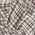 cream white, black, and brown, large plaid throw blanket twisted to show texture and colors
