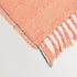 fancy orange cotton blend throw blanket displayed to show its eyelash tassel