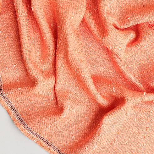 orange colored tweed eyelash throw blanket twisted to show pattern and texture