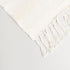 detailed cream colored throw blanket with unique patterns and tassels