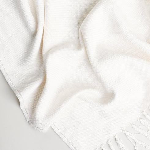 soft and cozy pure white throw blanket displayed to show tassels and color of fabric