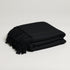 large soft textured black throw blanket folded up with tassels