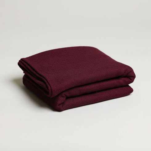 folded soft maroon throw blanket made from a cotton blend