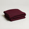 folded soft maroon throw blanket made from a cotton blend