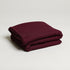 folded soft maroon throw blanket made from a cotton blend