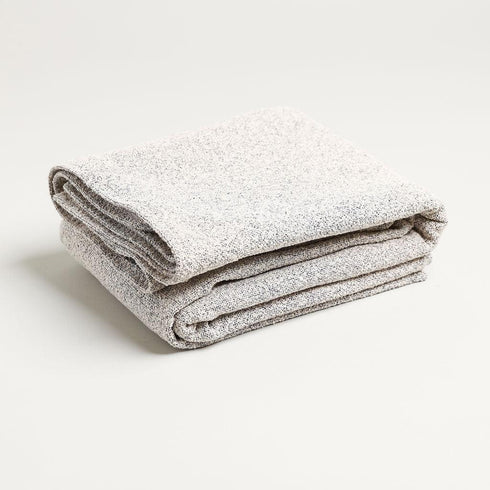 folded simple gray throw blanket with speckled colored look to it