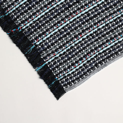 close up image of holiday navy blue, white, and black throw blanket showing texture and color