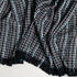 colorful blue and white and black throw blanket ruffled to show tassels and textured