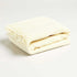 our pale yellow folded throw blanket with a fringe