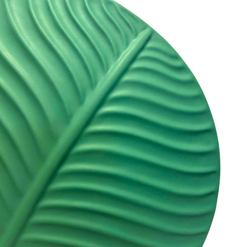 zoomed in to the right hand side of the dark green colored leaf pattern vase