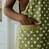 side of green apron with white polka dots