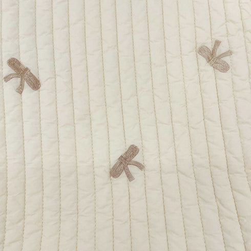 white quilt with bows folded close up