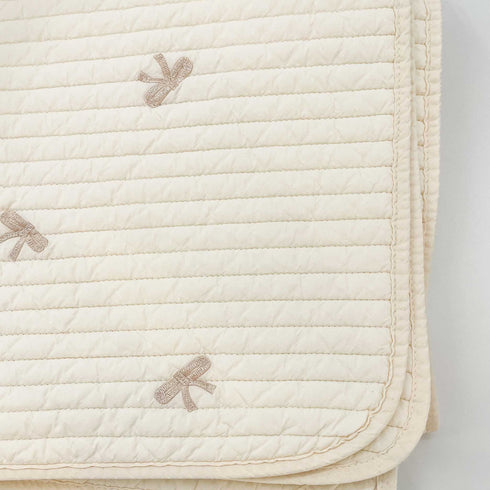 white quilt with brown bows