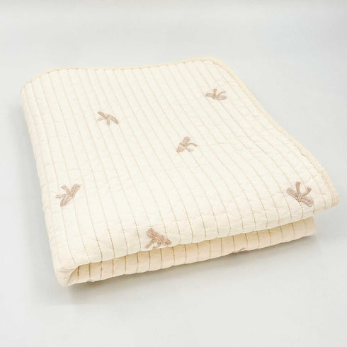 white quilt with brown bows folded